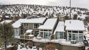 A modern multi-story house with large windows and a balcony, surrounded by a snowy landscape and other houses. - Charming 3-bedroom townhome with WiFi, fitness room in peaceful Redmond (Redmond)