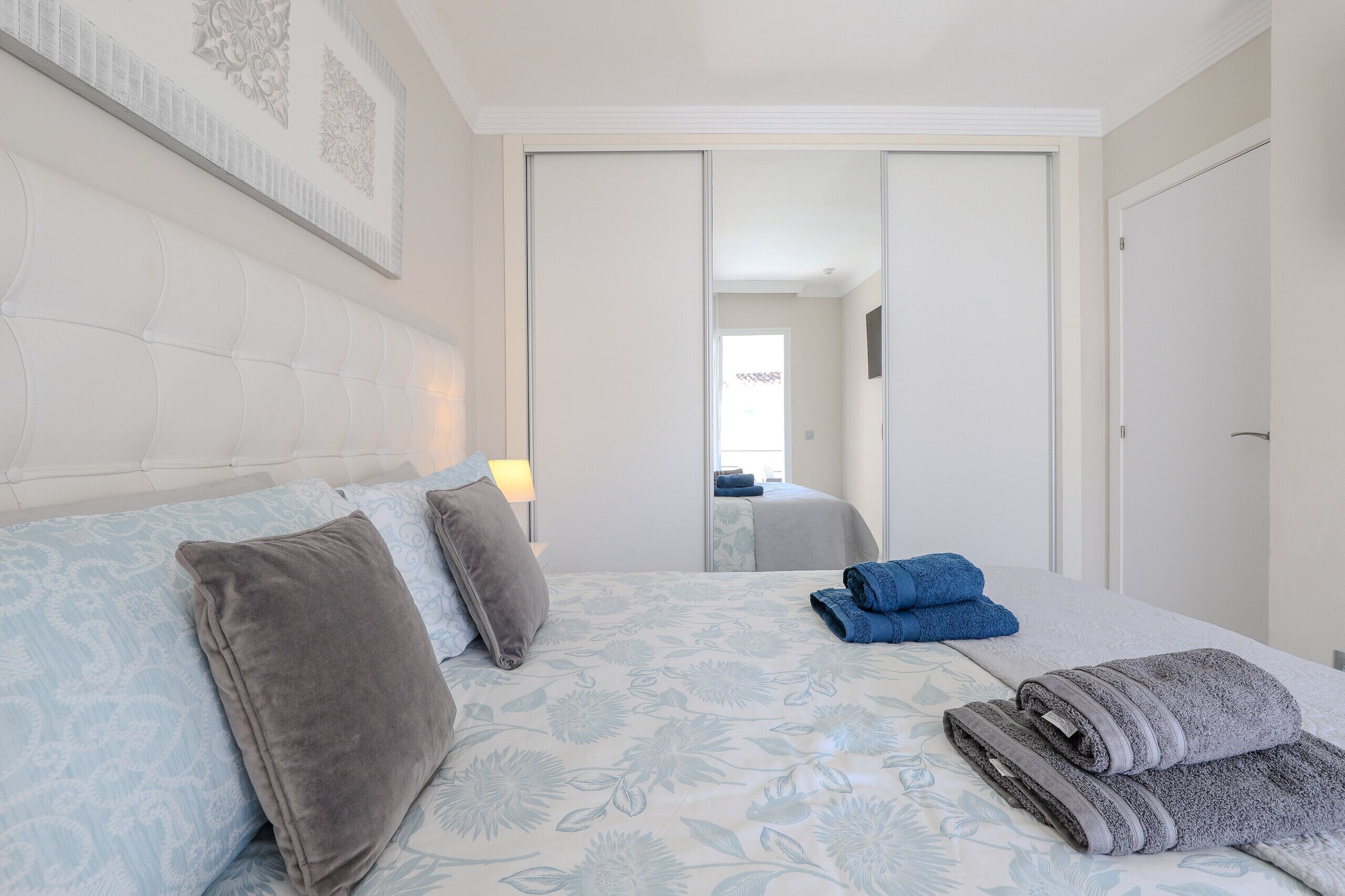 A hotel room with a bed, pillows, and towels.