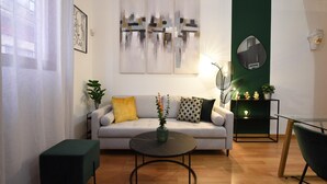 Un salon moderne comprenant un canapé, une table basse et une table d’appoint agrémentée d’objets décoratifs.