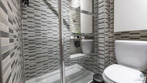 Une salle de bain moderne avec une douche à parois de verre, des toilettes et un lavabo.
