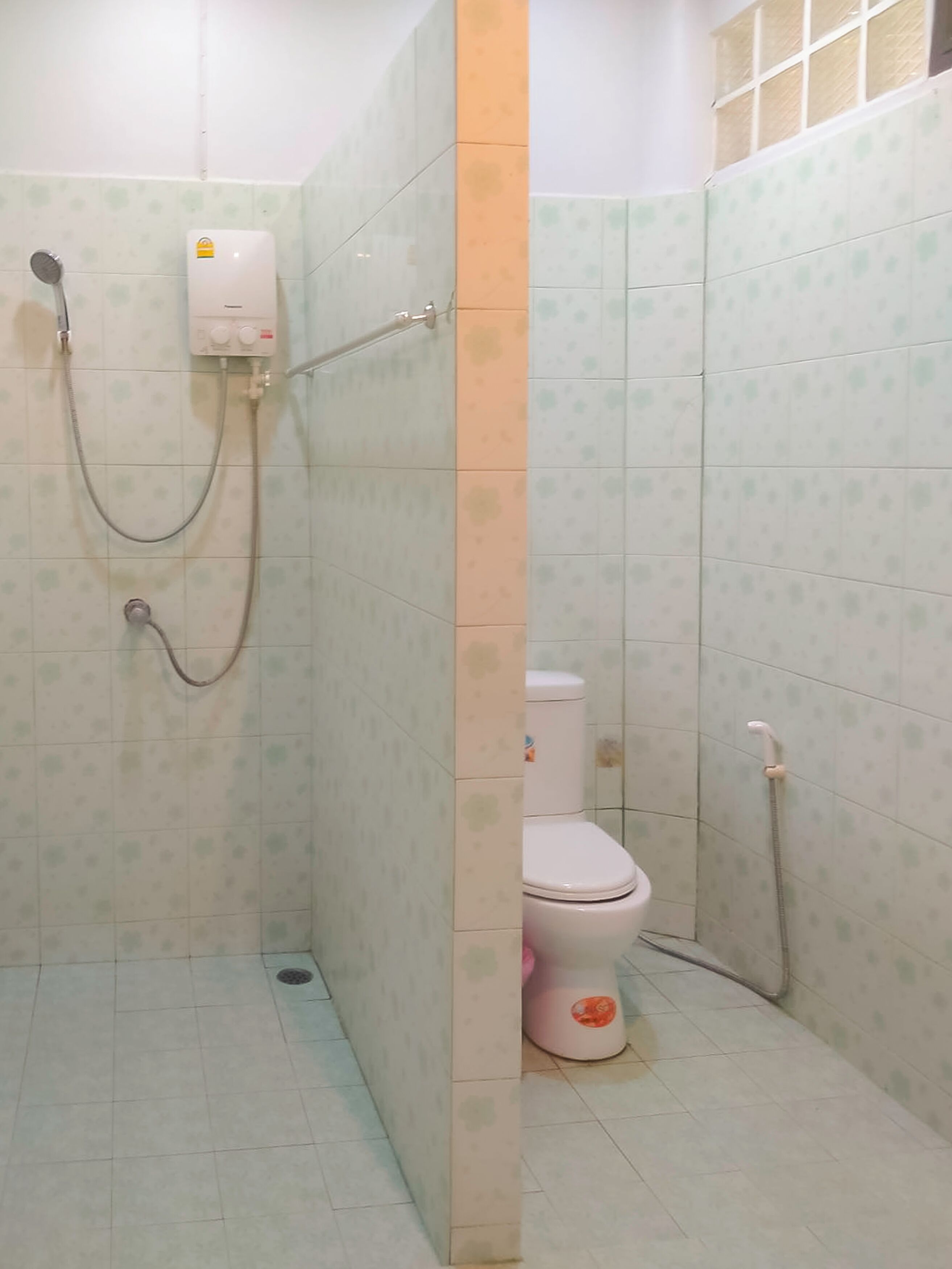 A bathroom with a shower, toilet, and a water heater.