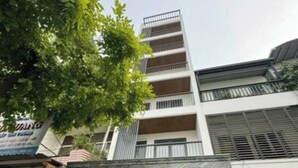A multi-story building with a gated entrance, a visible balcony on the upper floors, and a signboard on the ground floor. - SenseHome - 5 mins to Bui Vien street  (Ho Chi Minh City)
