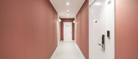 Un pasillo con una puerta blanca que dice 'STAFF ONLY' y el número 206, que da a una habitación.
