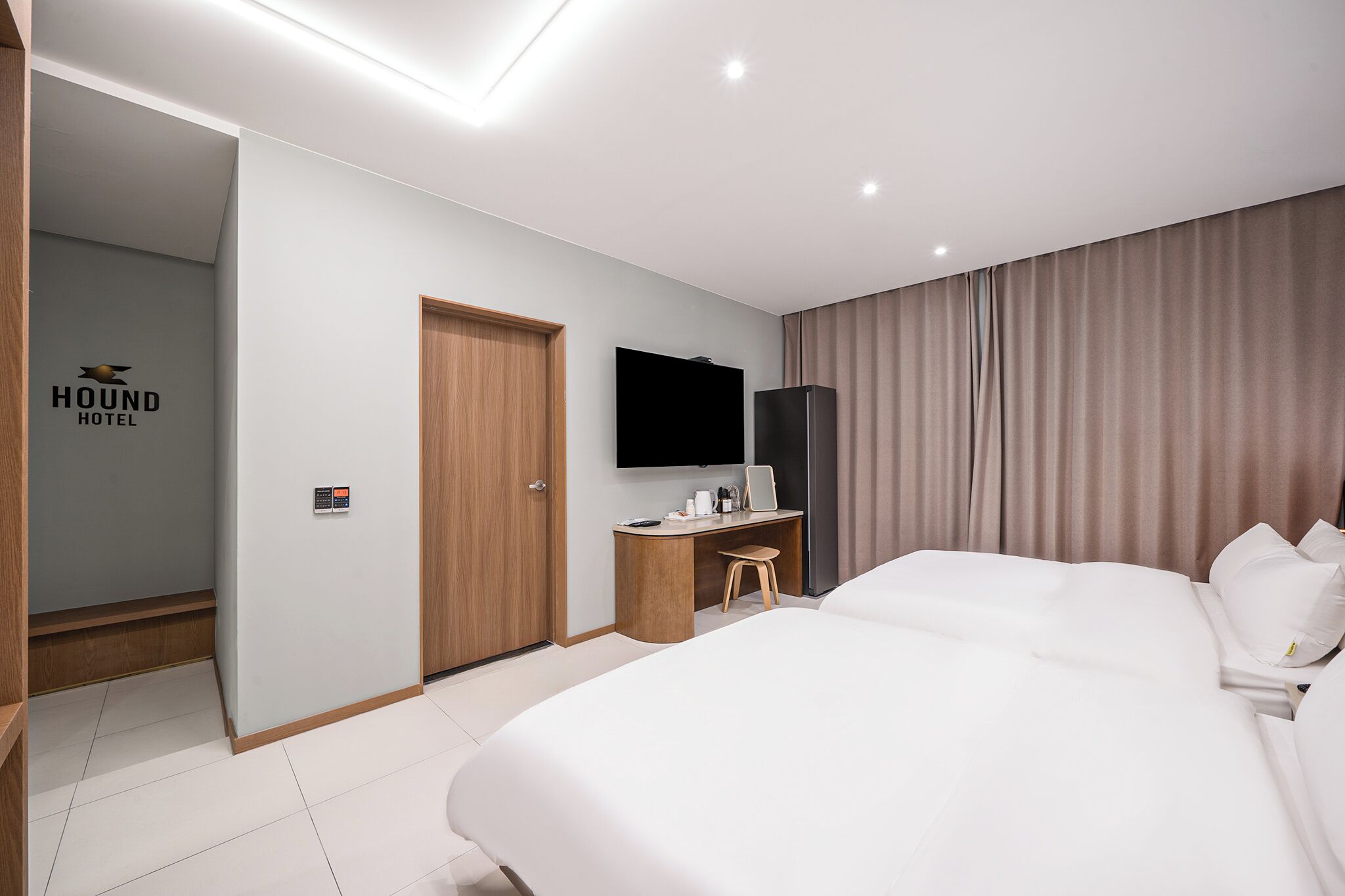 Habitación de hotel con una cama grande, un escritorio con silla, un televisor de pantalla plana y un armario.