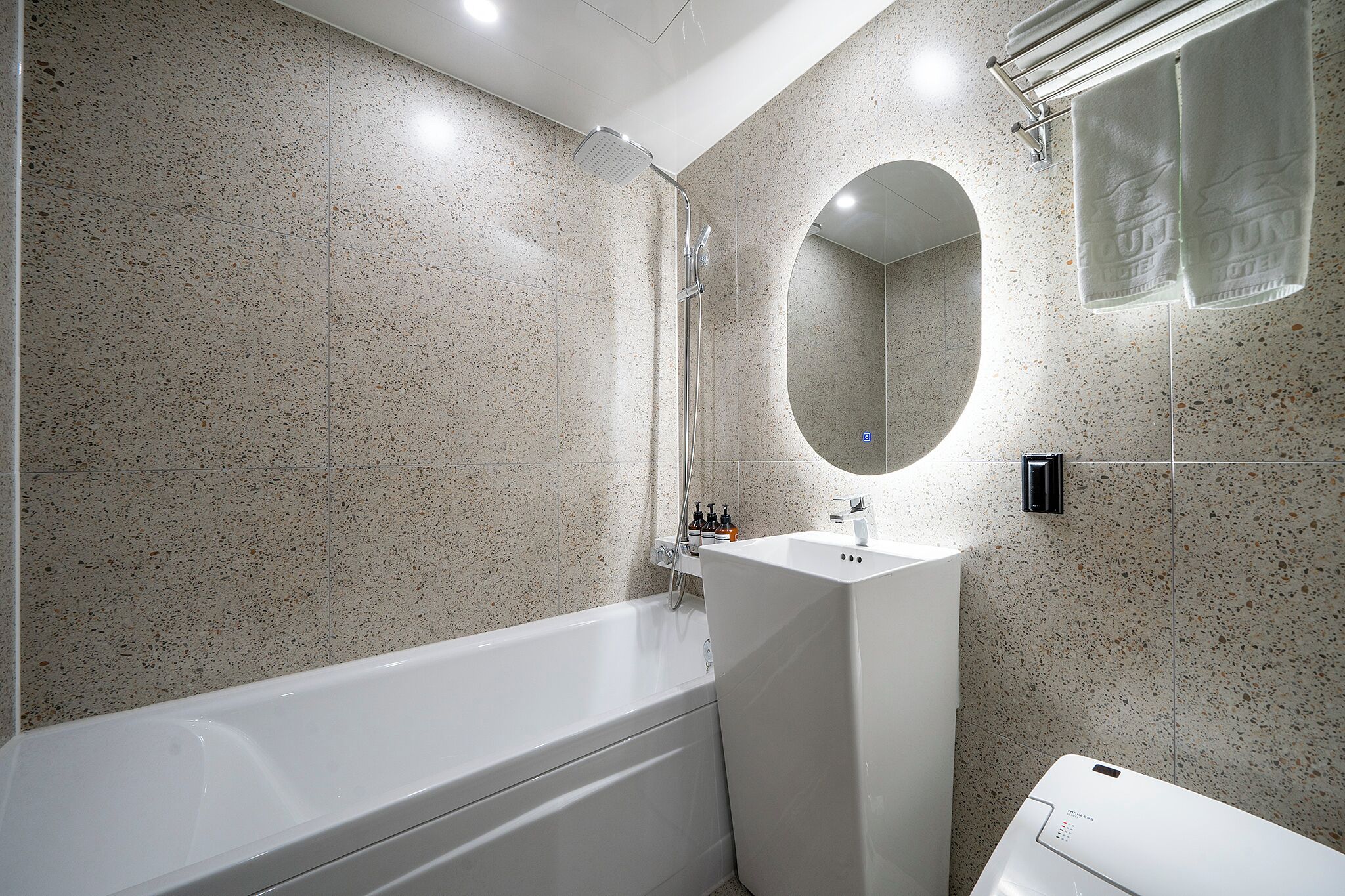 Ein modernes Badezimmer mit freistehender Badewanne, Waschbecken und Spiegel.