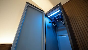A hotel room with a minibar, a built-in coffee machine, and a wooden panel wall.