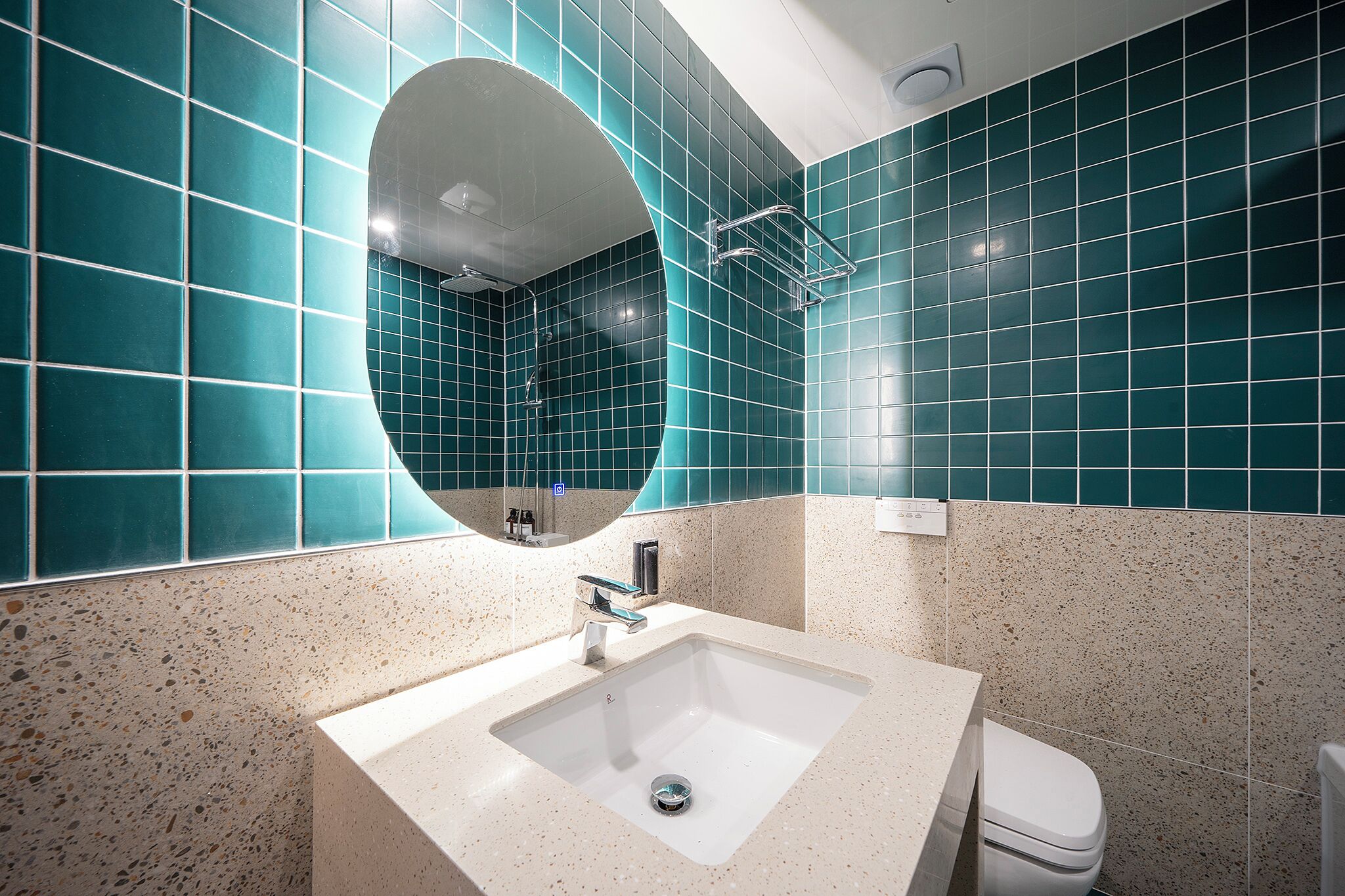 A bathroom with a white sink, a mirror, and a toilet.