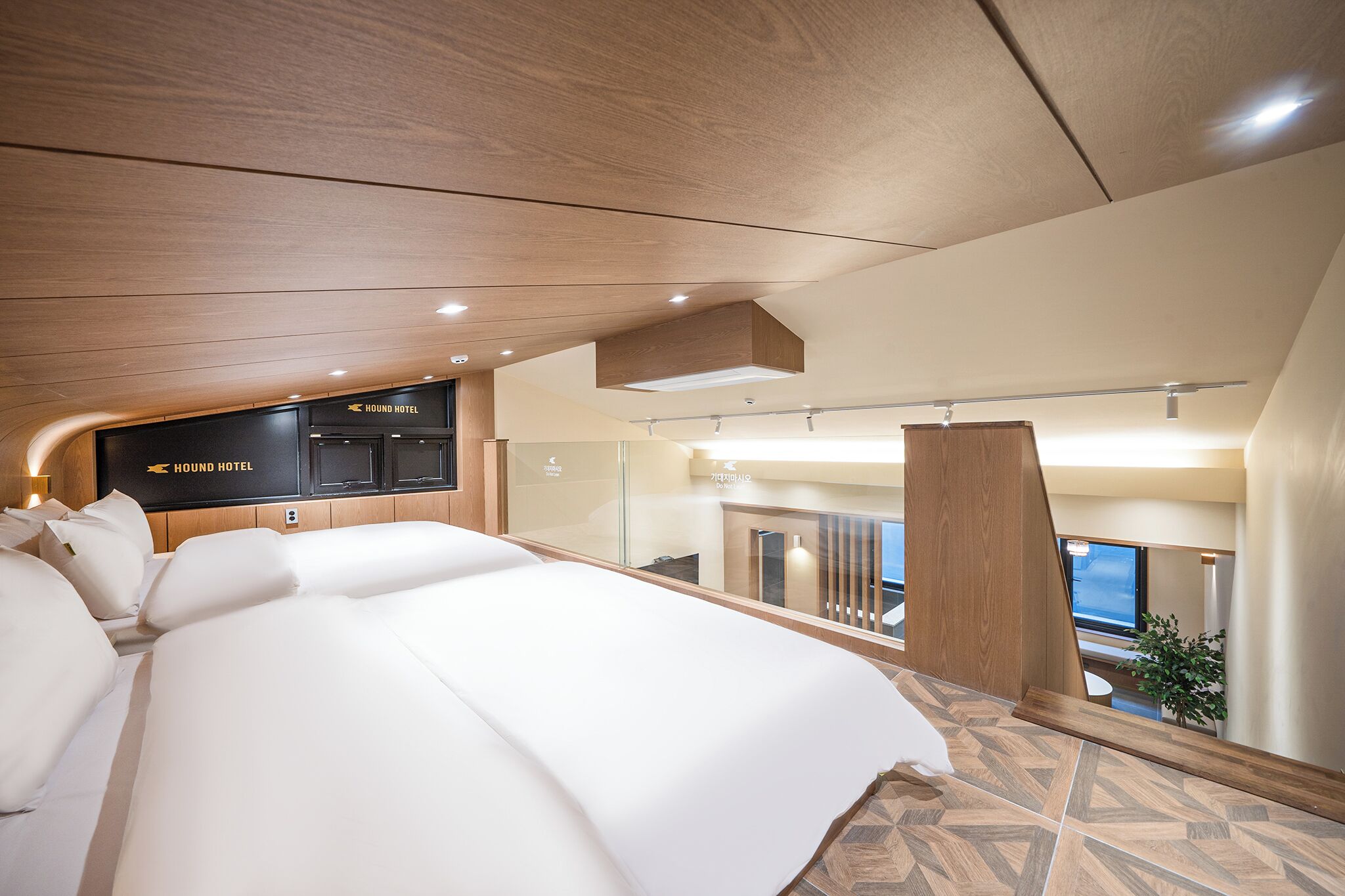 Un hotel moderno con una cama grande, un televisor montado en la pared y vistas a la ciudad desde la ventana.