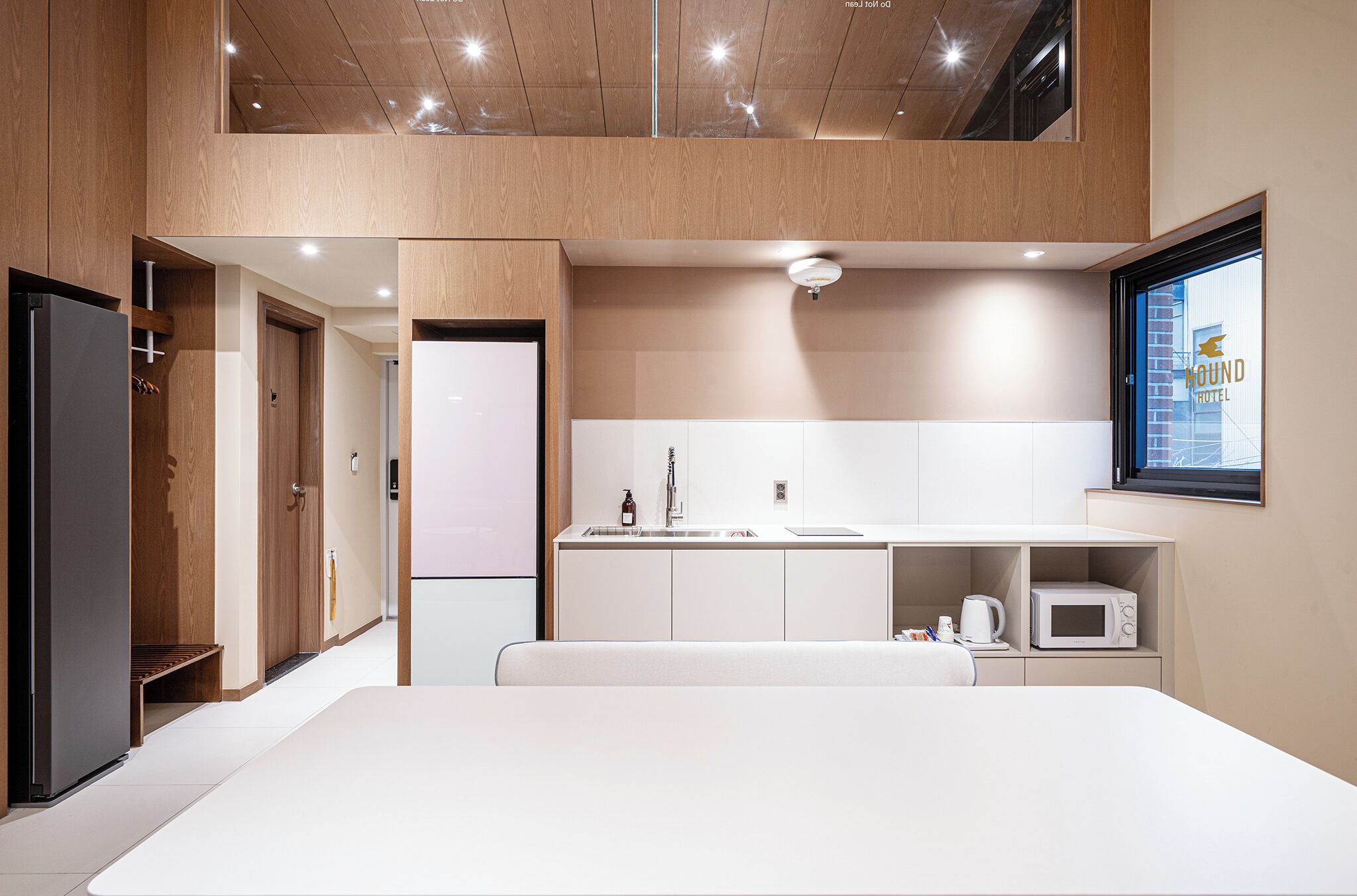 Una habitación de hotel moderna con kitchenette, una cama grande y vistas del exterior del hotel.