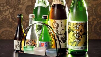 Diverses ampolles de sake i una tradicional safata de te japonesa damunt d'una taula.