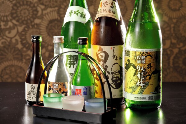 Varias botellas de sake y un juego de té japonés tradicional sobre una mesa.