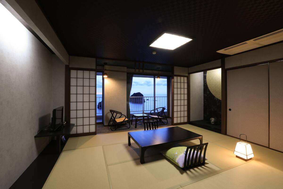 Une pièce de style japonais traditionnel, avec un sol recouvert de tatamis, une table basse et une porte coulissante.