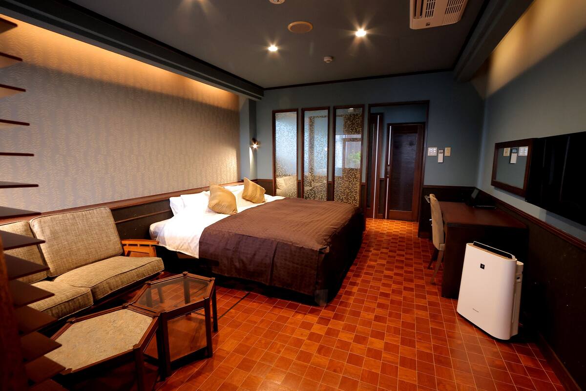 Une chambre d’hôtel avec un lit, un canapé et un bureau.