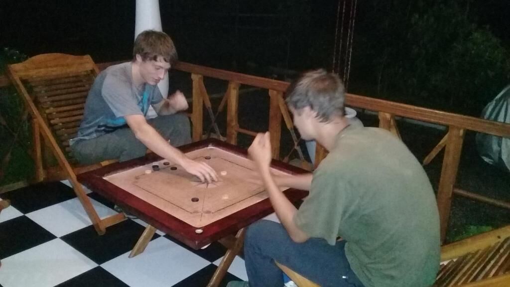 Two people playing a board game on a checkered floor.