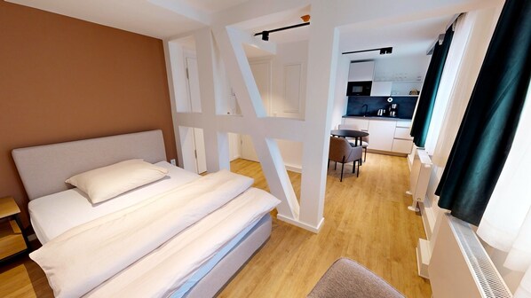 Relax in a spacious room with a large bed, kitchenette, and seating area.