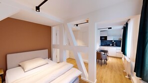 Relax in a spacious room with a large bed, compact kitchen, and dining area.