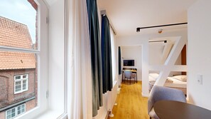 Enjoy a compact room with a large window, single bed, and desk area.