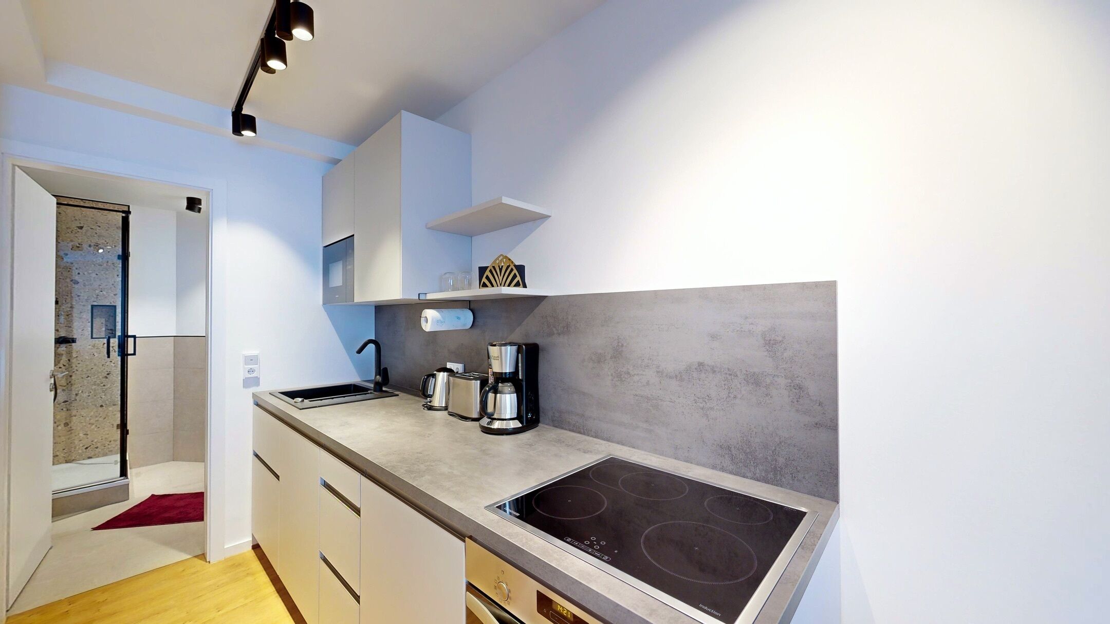 Una cocina moderna con una placa de inducción integrada, una cafetera y un tostador.