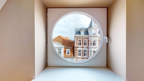 Una ventana circular con vistas a edificios tradicionales europeos.