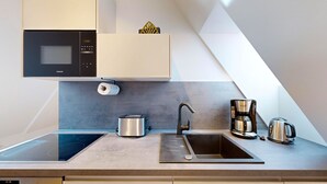 Una cocina moderna equipada con microondas, tostadora, hervidor y cafetera.
