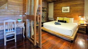 Une pièce en bois contenant un lit, une chaise, une table et une armoire.