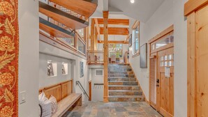 A spacious hallway with a wooden staircase, a bench, and a view of the upper floor. - Northstar Ski-In/Ski-Out with Hot Tub & Views (Northstar)