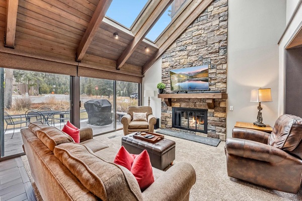 Living Room: Couch, 2 chairs, 55” TV w/cable, sound bar, gas fireplace, vaulted ceilings, skylights, open layout