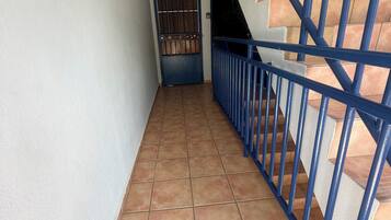 Una escalera con barandillas azules y suelo de baldosas.