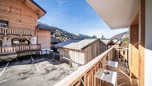 Un edificio de madera con un balcón que da a un paisaje montañoso.