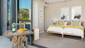 Un dormitorio con cama, una mesa con desayuno y un balcón con vistas.