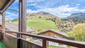 A wooden balcony with a view of a village and mountains. - Réséda : Calme Montagnard avec Vue Apaisante (LE GRAND BORNAND)