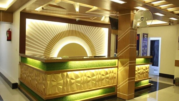 Un comptoir d’accueil au design moderne, avec une palette de couleurs vertes et beiges et un motif géométrique original sur la partie inférieure.