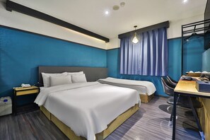 Hotellihuone, jossa on kaksi sänkyä, työpöytä ja tuoli.