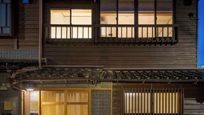 Une maison traditionnelle en bois, avec un porche carrelé et un balcon.