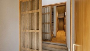 Une porte coulissante traditionnelle de style japonais qui donne sur un escalier.