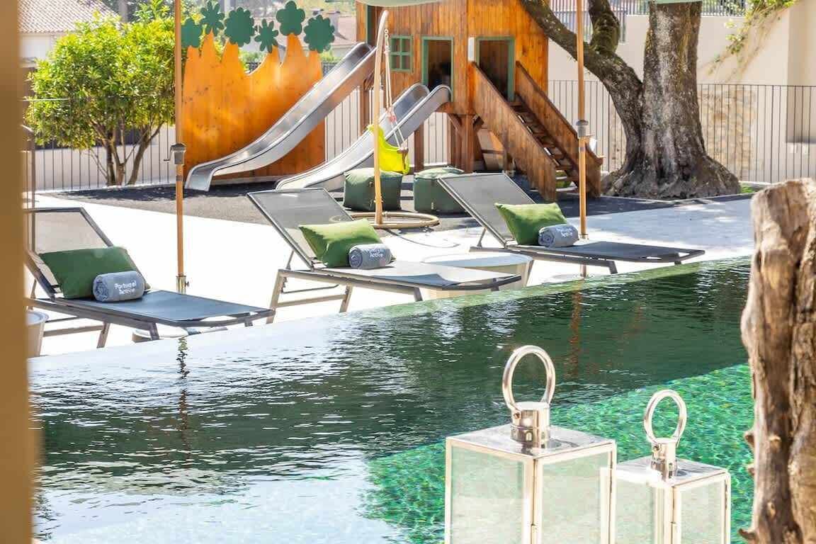 An outdoor swimming pool with lounge chairs and a slide.