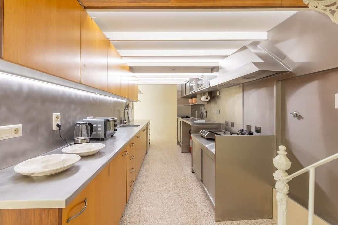Una cocina moderna con electrodomésticos de acero inoxidable, armarios de madera y encimera de color claro.