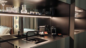 A modern hotel room with a large bed, a built-in kitchen with a sink, and a minibar. - Zeta Rentals  (Bari)