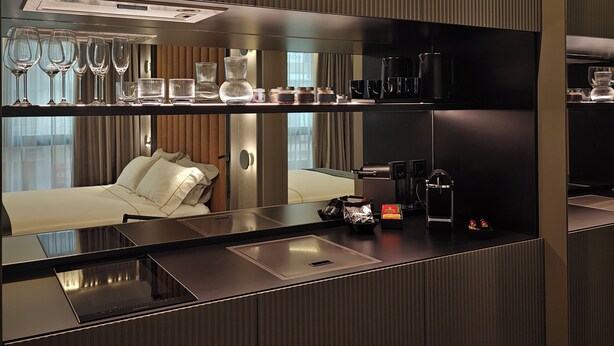 A modern hotel room with a kitchenette, a bed, and a large mirror. - Zeta Rentals  (Bari)
