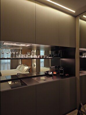 A modern hotel room with a kitchenette, a bed, and a large mirror. - Zeta Rentals  (Bari)