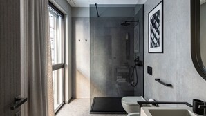 A modern bathroom with a shower, toilet, and sink. - Zeta Rentals  (Bari)