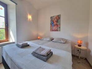 A bedroom with two beds, a window, and a painting on the wall. - Holiday house for 6 guests with private pool (Aigues-Vives)