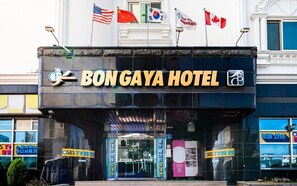 Das äußere Erscheinungsbild des Hotels Bon Gaya mit Flaggen der USA, Chinas, Südkoreas und Kanadas.