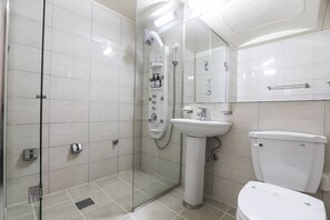 A modern bathroom with a glass shower enclosure, a pedestal sink, and a toilet. - Bon Gaya Hotel (Boryeong)