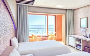 A hotel room with a bed, a desk, a chair, and a view of the sea. - Bon Gaya Hotel (Boryeong)