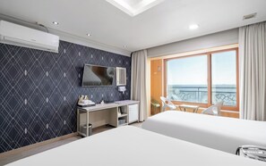 Une chambre d’hôtel avec un lit, un bureau, une télévision, un balcon avec vue et une fenêtre.