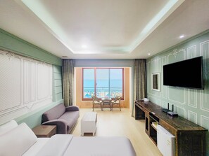 A hotel room with a balcony, a sofa, a bed, a desk, and a TV. - Bon Gaya Hotel (Boryeong)