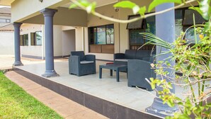 Eine Terrasse im Freien mit Sitzgelegenheiten und einem Fernseher.