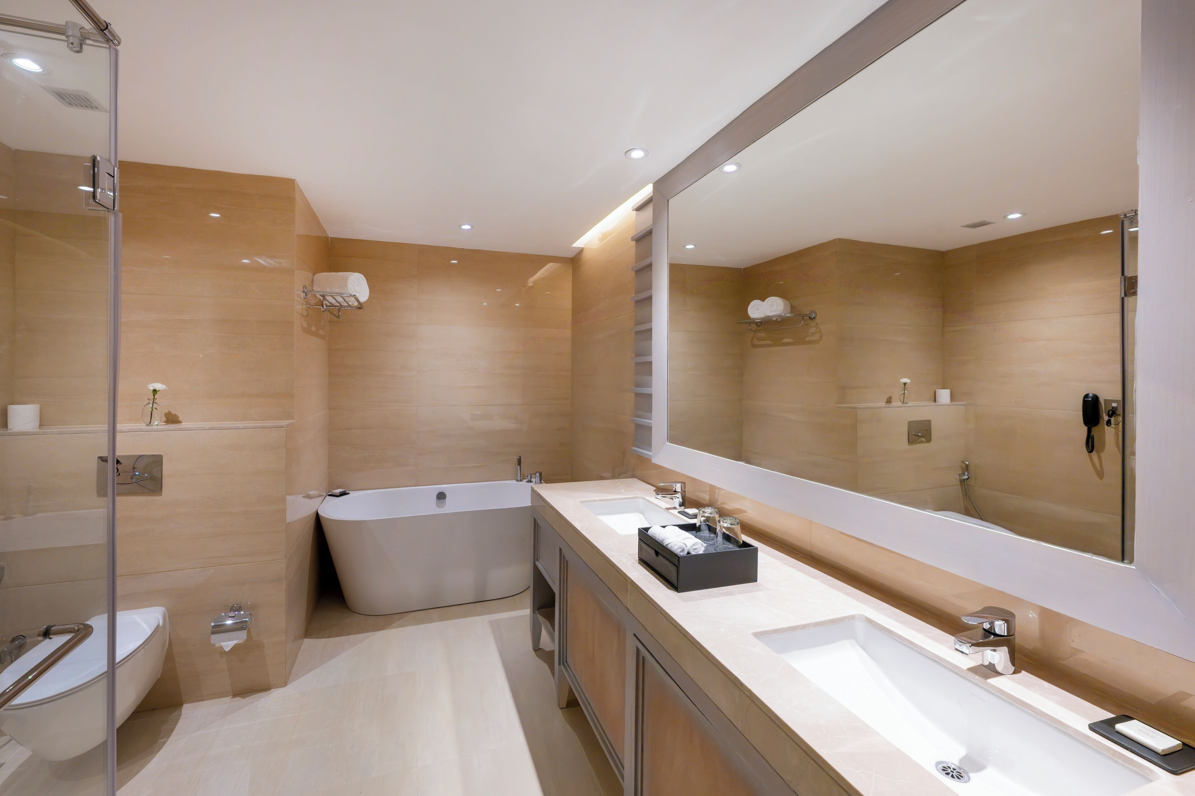 Un bagno moderno con uno specchio grande, due lavabi, una vasca e una doccia.