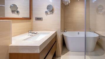 A modern bathroom with a large freestanding bathtub, a double sink vanity, and a mirror above the sink.